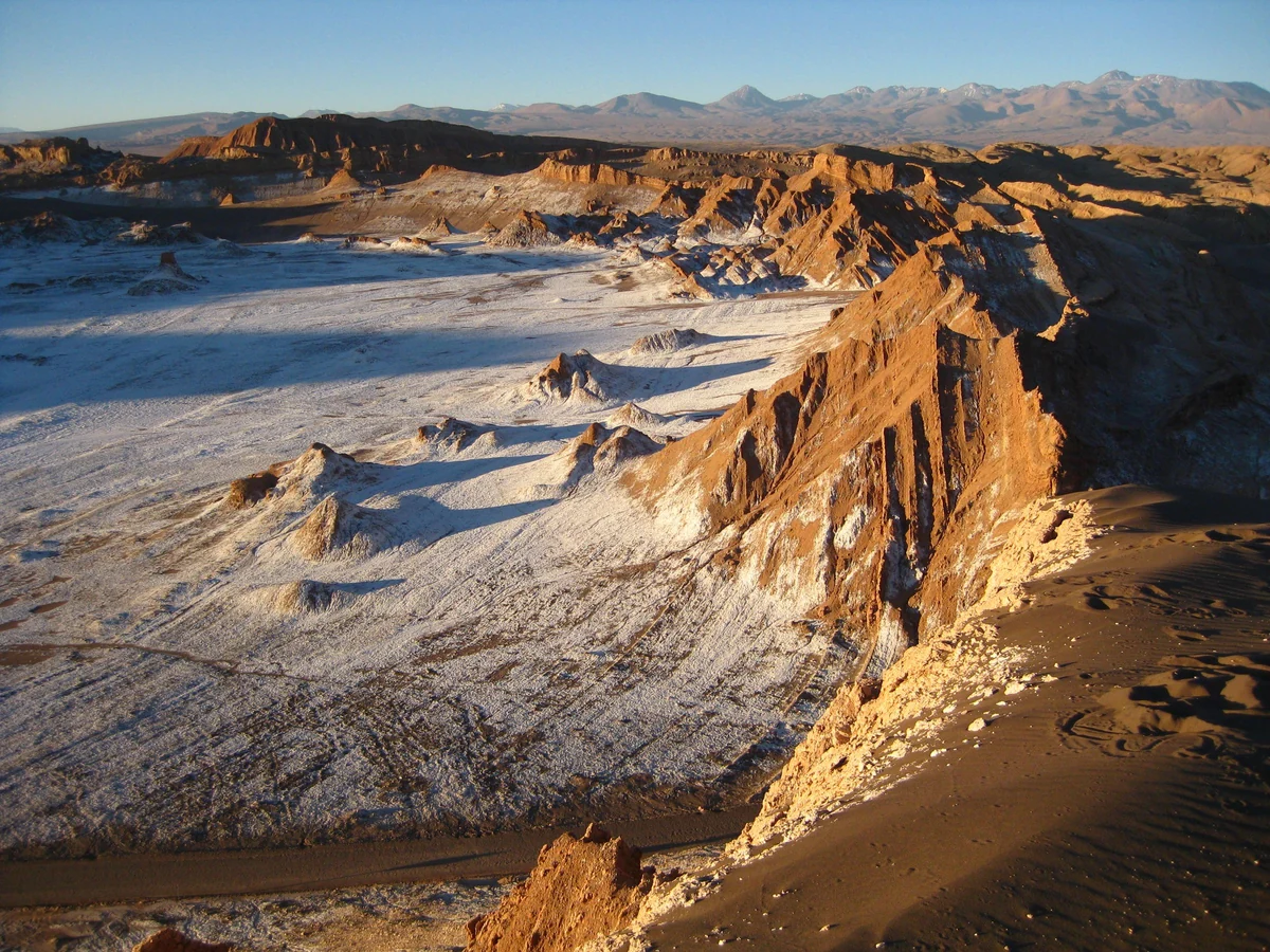 Vale de sal e paredões de rocha do Valle de la Luna com luz de fim de tarde
